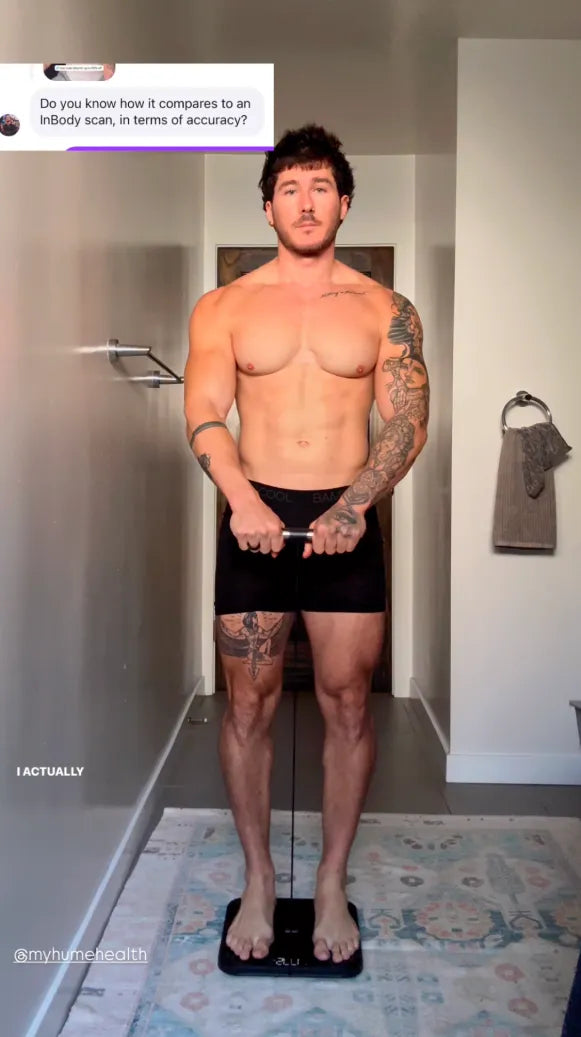 Man standing on a scale in a bathroom, shirtless and wearing black underwear.
